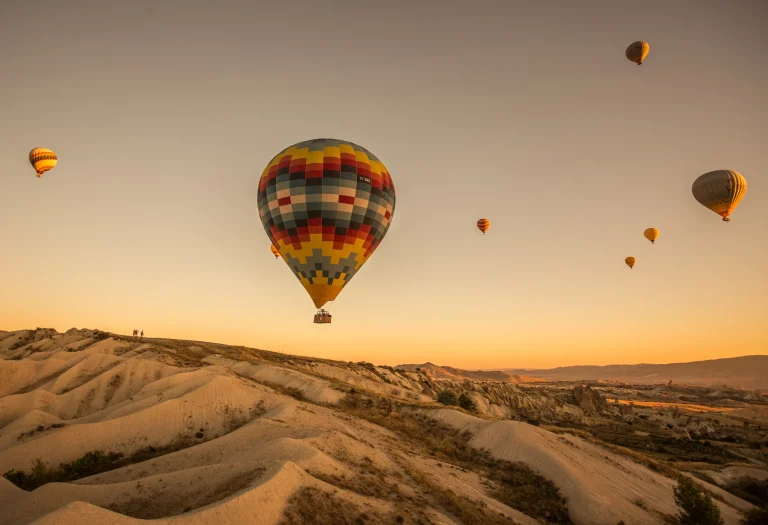 globos-de-aire-caliente-sobre-las-colinas-y-los-campos-durante-la-puesta-de-sol-en-capadocia-turquia