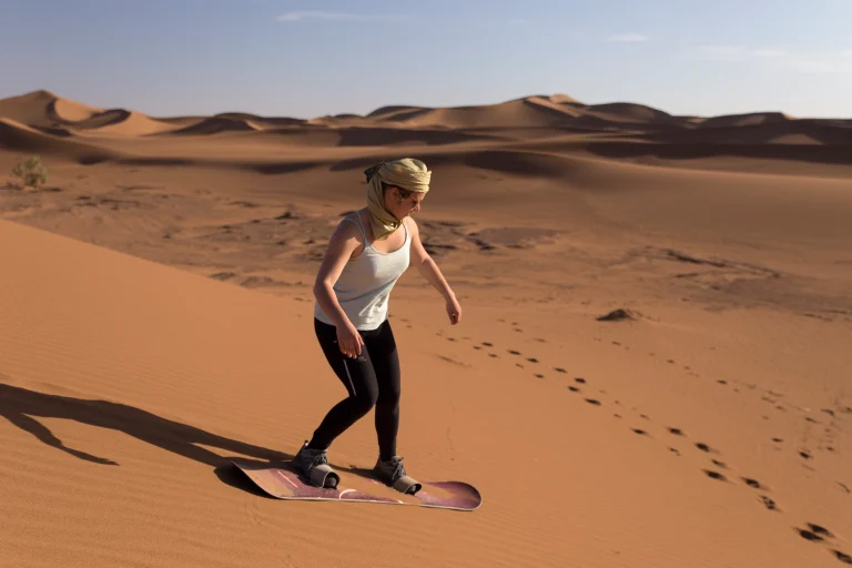 la-longitud-completa-de-una-adolescente-haciendo-sandboard-en-el-desierto